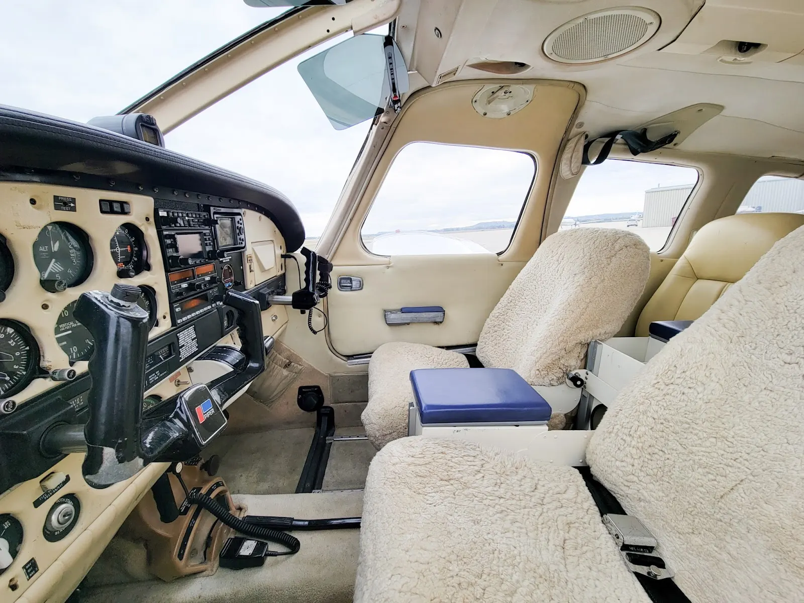 Pilot seat and panel seen through the cabin door